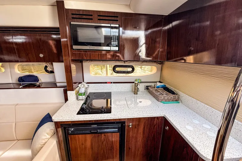 Slide: The Image of Luxurious 2016 Sea Ray Sundancer 350 yacht kitchen with modern appliances and elegant wood cabinetry. - 32