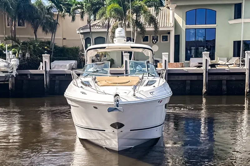 Slide: The Image of 2016 Sea Ray Sundancer 350 yacht docked near waterfront homes with palm trees. - 1