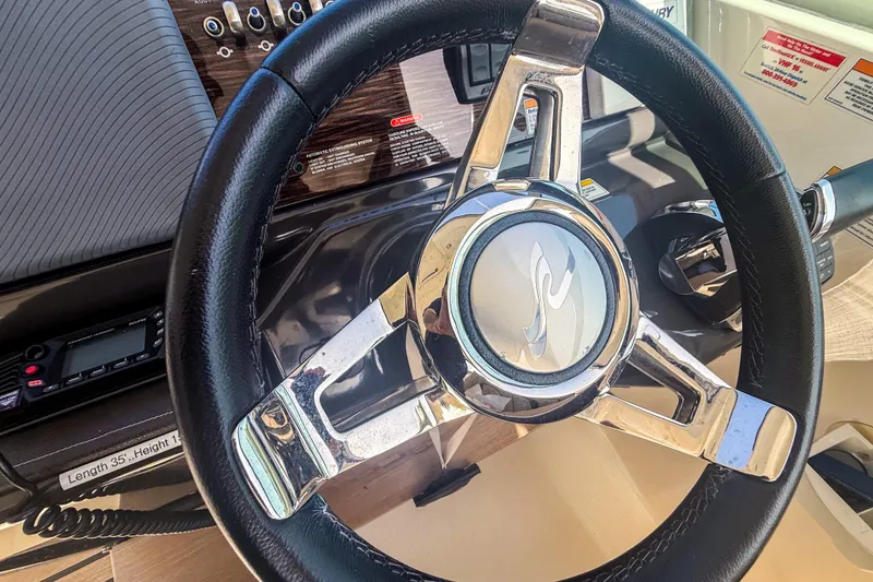 Slide: The Image of Steering wheel of a 2016 Sea Ray Sundancer 350 boat cockpit. - 23