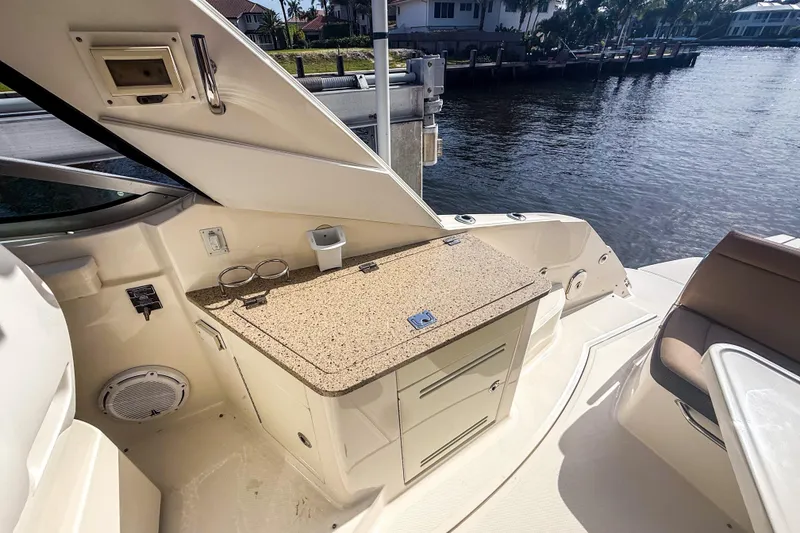 Slide: The Image of Interior view of 2016 Sea Ray Sundancer 350 yacht with kitchenette and waterfront backdrop. - 15