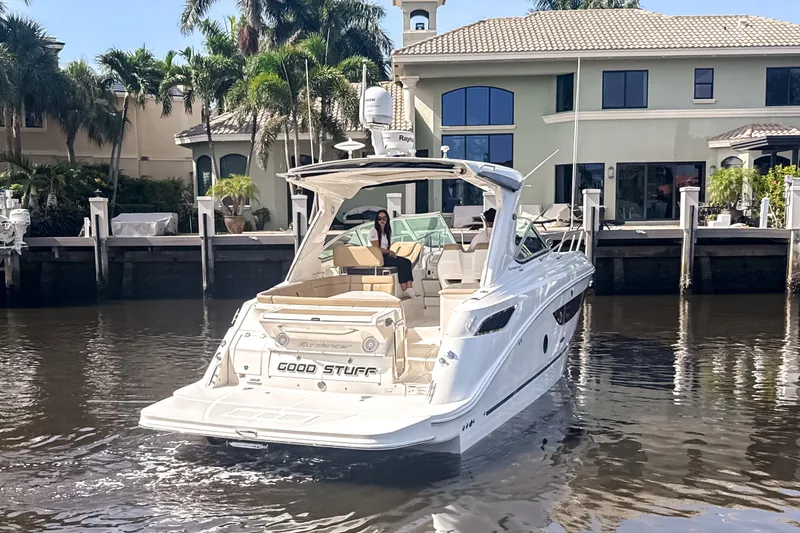 Slide: The Image of 2016 Sea Ray Sundancer 350 yacht docked near waterfront homes, surrounded by palm trees. - 5