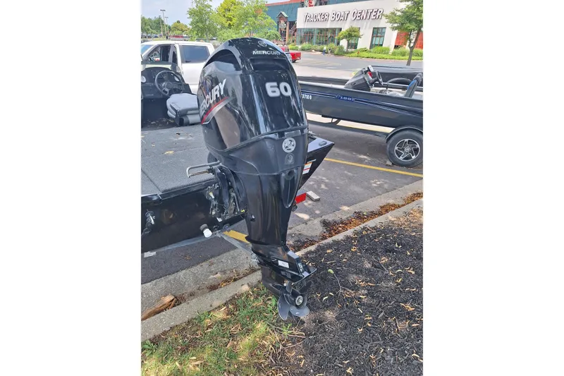 Slide: The Image of Boat motor attached to a trailer in a parking lot near a boat center. - 6