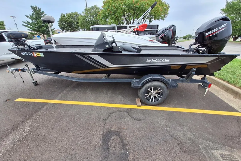 Slide: The Image of 2023 Lowe Skorpion 17 fishing boat on trailer, parked outdoors. - 18