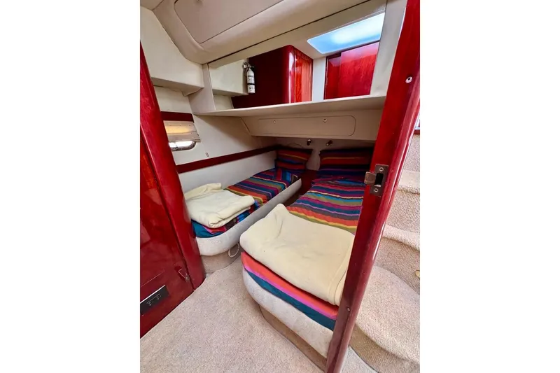 Slide: The Image of Cozy cabin interior of 1999 Birchwood Challenger 450 Flybridge with twin beds and colorful bedding. - 38