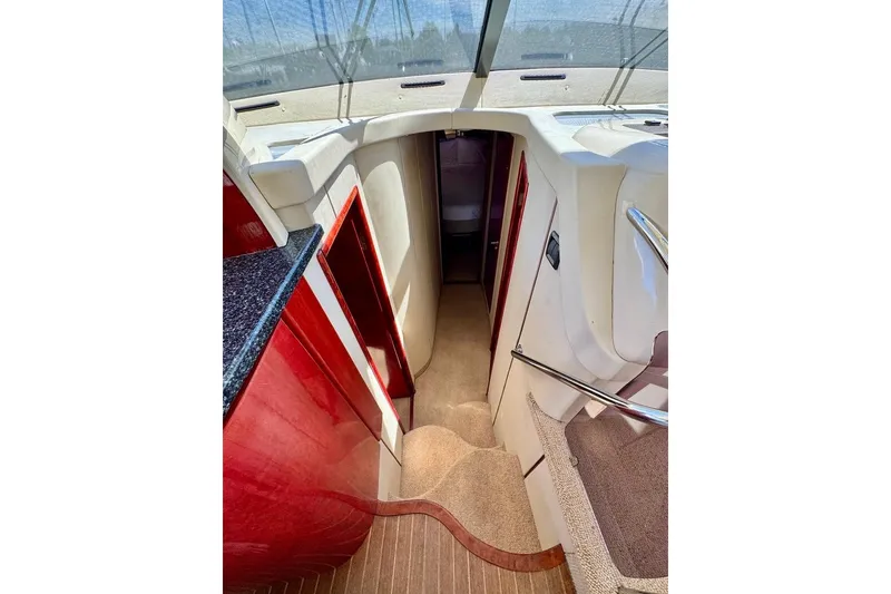 Slide: The Image of Interior view of 1999 Birchwood Challenger 450 Flybridge yacht with red cabinetry and carpeted stairs. - 31