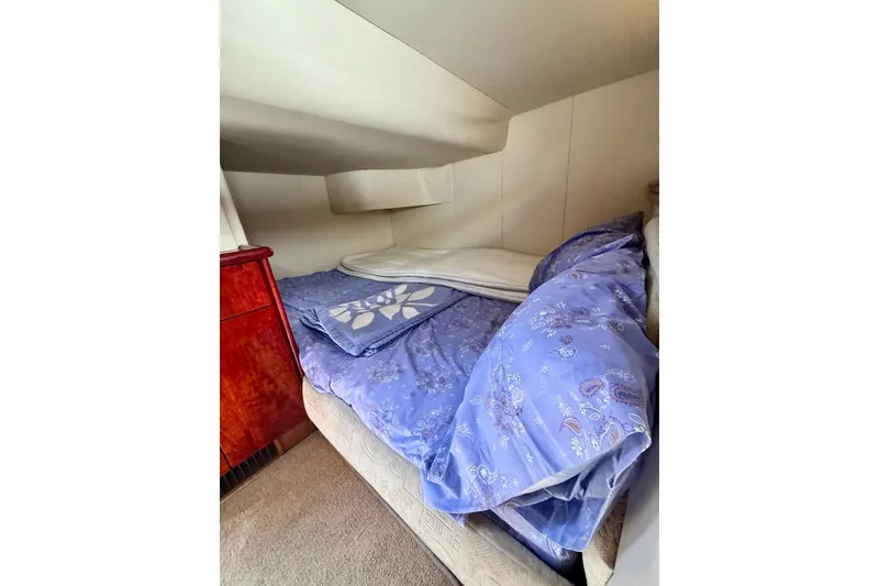 Slide: The Image of Cozy cabin bed in 1999 Birchwood Challenger 450 Flybridge yacht, featuring blue floral bedding. - 44
