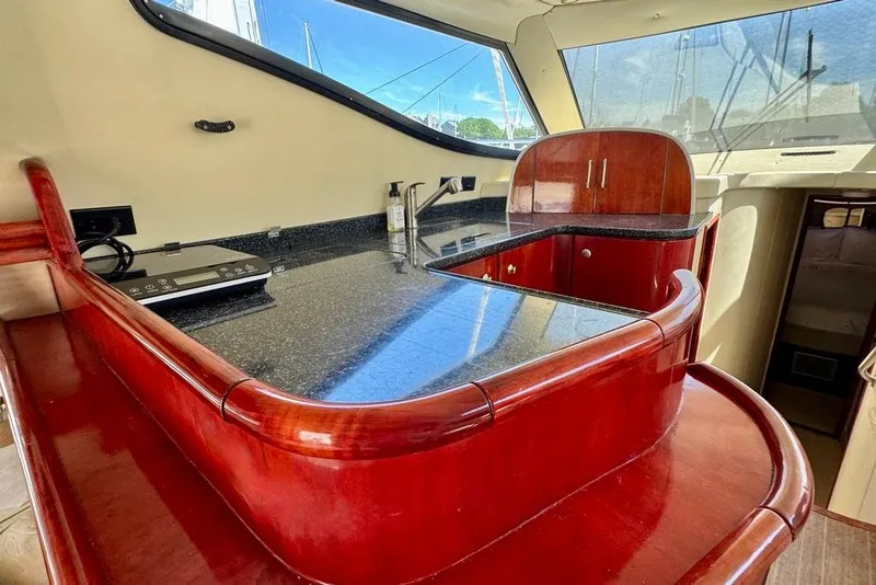 Slide: The Image of Luxurious interior of 1999 Birchwood Challenger 450 Flybridge yacht with polished wood and granite surfaces. - 23