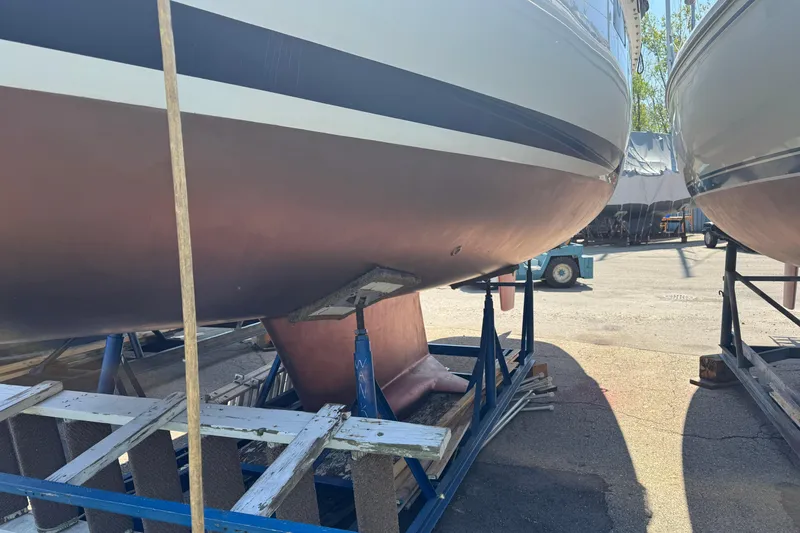 Slide: The Image of 1993 Hunter 33.5 sailboat on stands in a boatyard, showing hull and keel. - 8