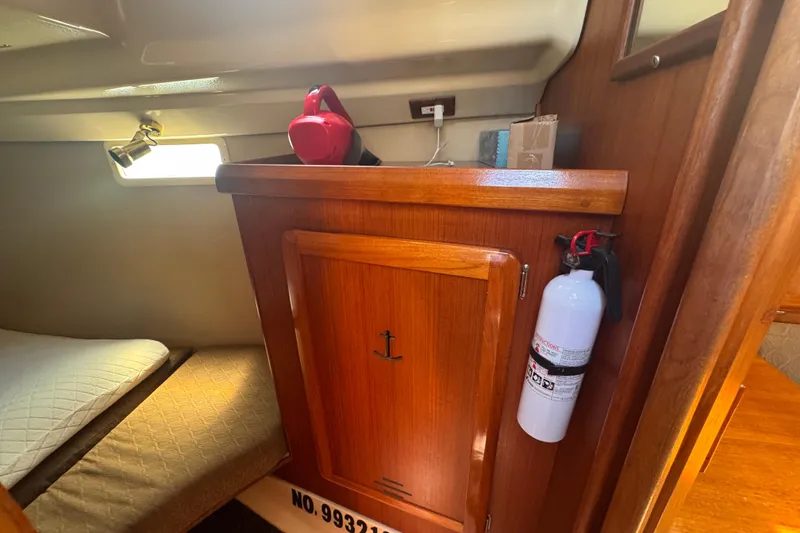 Slide: The Image of Interior of a 1993 Hunter 33.5 sailboat cabin with wooden cabinetry and fire extinguisher. - 36
