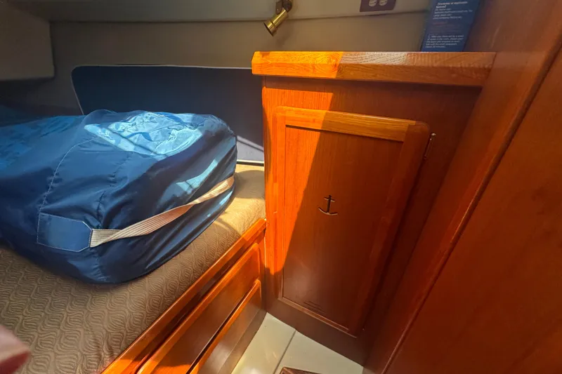 Slide: The Image of Cozy cabin interior of 1993 Hunter 33.5 sailboat with wooden cabinetry and blue bedding. - 37