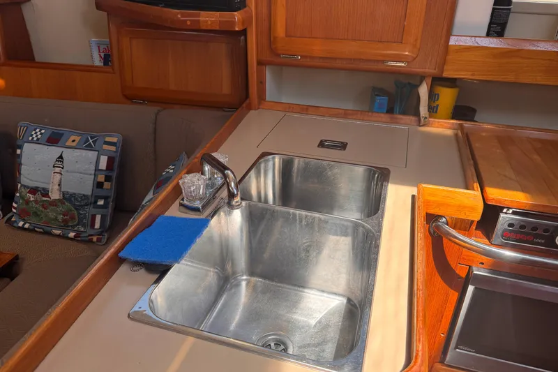 Slide: The Image of Interior of a 1993 Hunter 33.5 sailboat featuring a kitchen sink and wooden cabinetry. - 29