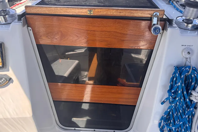 Slide: The Image of Wooden hatch door on a 1993 Hunter 33.5 sailboat, featuring a lock and blue rope. - 21