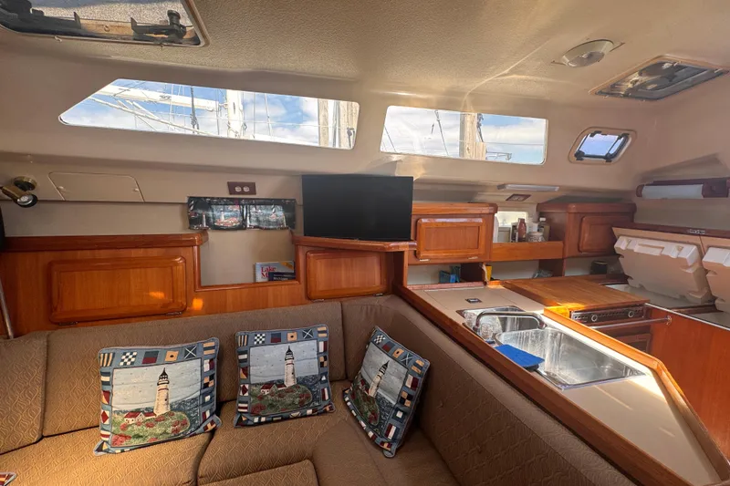 Slide: The Image of Interior of a 1993 Hunter 33.5 sailboat with cozy seating and wooden cabinetry. - 33