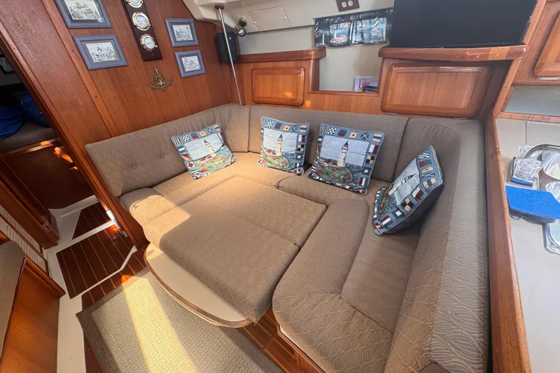 Slide: The Image of Cozy interior of a 1993 Hunter 33.5 sailboat with cushioned seating and nautical decor. - 32