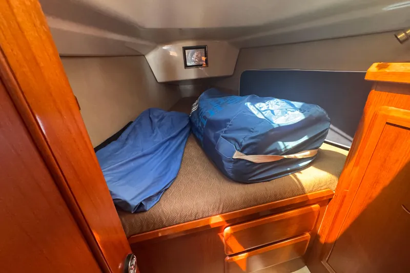 Slide: The Image of Cozy cabin interior of 1993 Hunter 33.5 sailboat with blue bedding and storage. - 38
