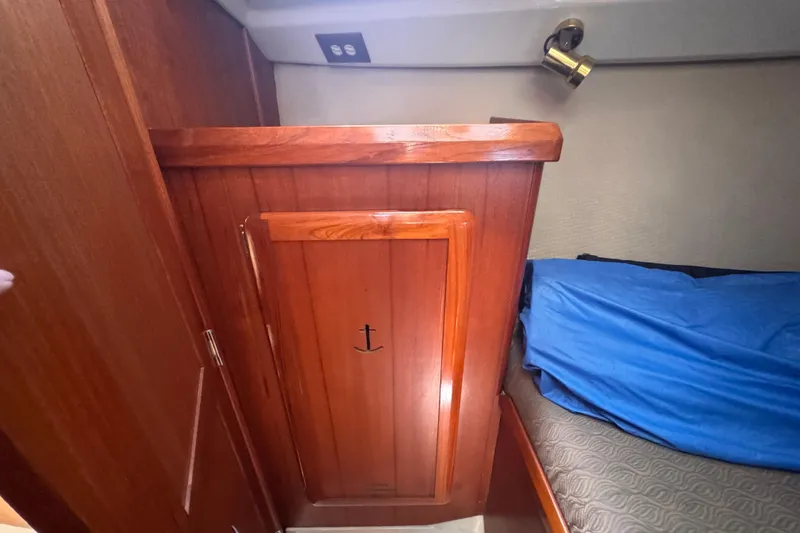 Slide: The Image of Interior cabin of a 1993 Hunter 33.5 sailboat with wooden paneling and blue bedding. - 39