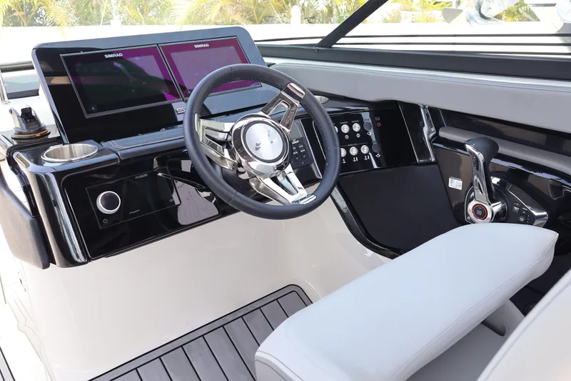 Slide: The Image of 2024 Sea Ray SLX 260 Outboard helm with modern controls and dual Simrad displays. - 22