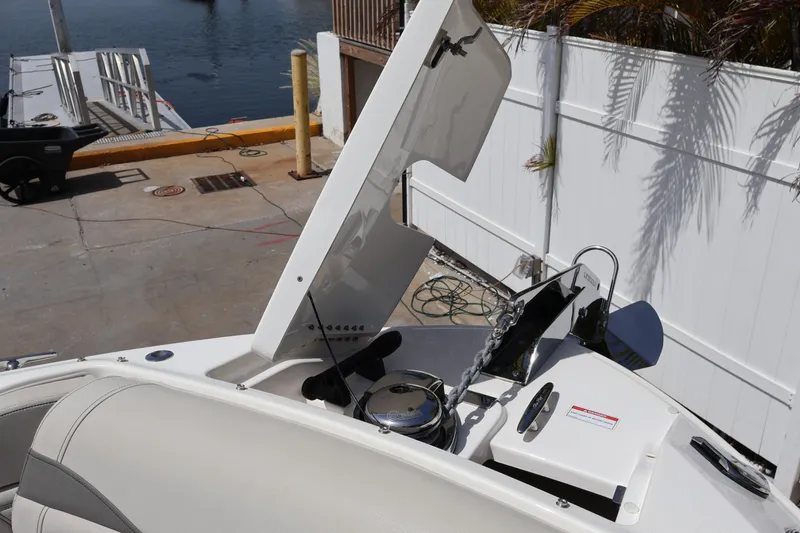 Slide: The Image of 2024 Sea Ray SLX 260 Outboard boat with open anchor compartment at dockside. - 14
