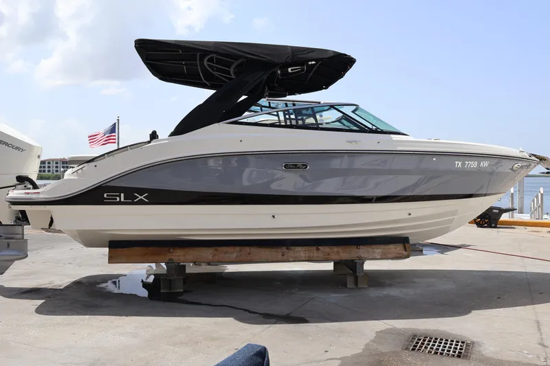 Slide: The Image of 2024 Sea Ray SLX 260 Outboard boat on dock, American flag in background. - 4