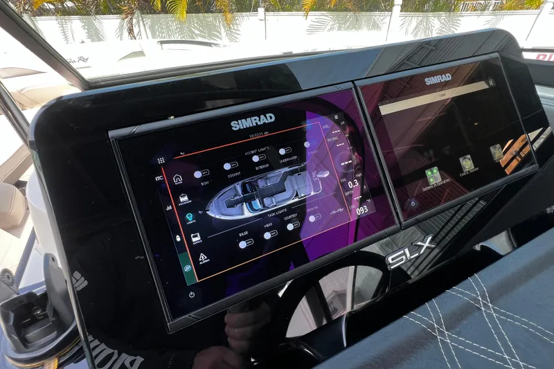 Slide: The Image of 2024 Sea Ray SLX 260 Outboard dashboard with dual Simrad displays and advanced navigation controls. - 23