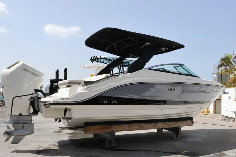 The Image of 2024 Sea Ray SLX 260 Outboard boat with Mercury engine, docked outdoors. - 0