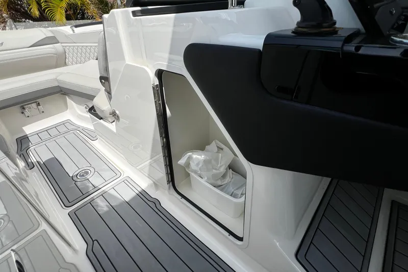 Slide: The Image of 2024 Sea Ray SLX 260 Outboard interior with storage compartment and sleek flooring design. - 21