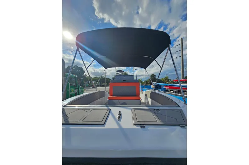 Slide: The Image of 2026 Murano 205 boat with canopy, docked under a partly cloudy sky. - 35