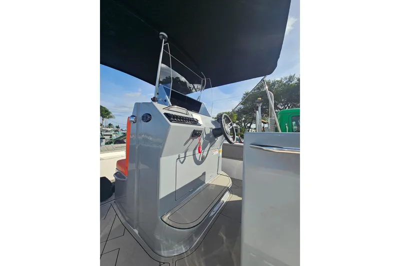 Slide: The Image of 2026 Murano 205 boat console with steering wheel and canopy, docked outdoors. - 28