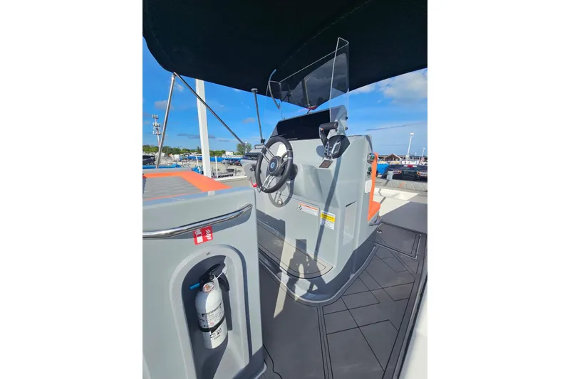 Slide: The Image of 2026 Murano 205 boat cockpit with steering wheel and fire extinguisher, docked under clear sky. - 34