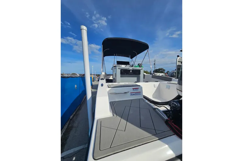 Slide: The Image of 2026 Murano 205 boat with sleek deck design and canopy under clear blue sky. - 26