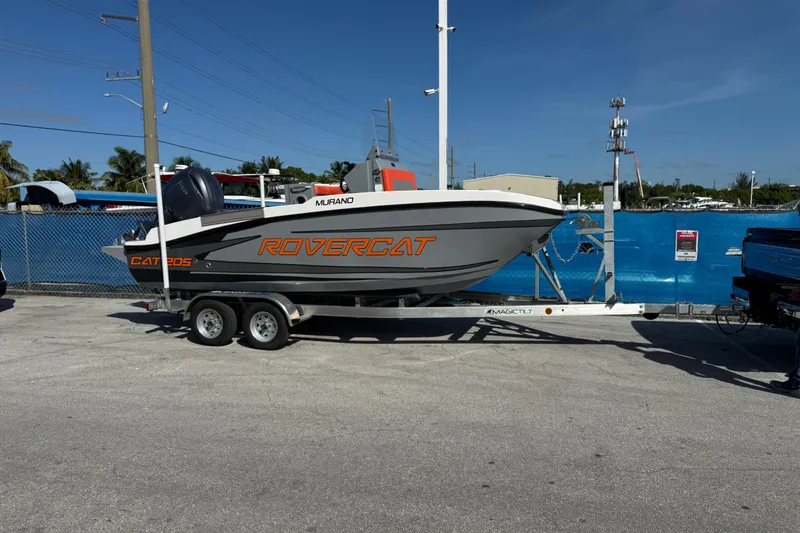Slide: The Image of 2026 Murano 205 Rovercat boat on trailer, parked outdoors under clear blue sky. - 37