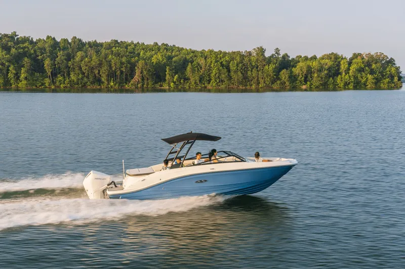 Slide: The Image of A 2024 Sea Ray SPX 230 Outboard speeds across a calm lake, surrounded by trees. - 16
