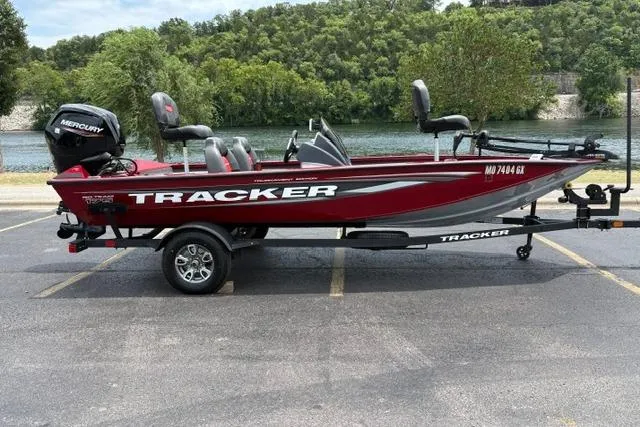 The Image of 2025 Tracker Off Road Pro Team 175 boat, red, parked near a scenic river. - 1