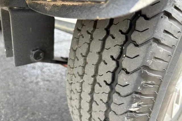 Slide: The Image of Close-up of a 2025 Tracker Off Road Pro Team 175 tire on pavement. - 48