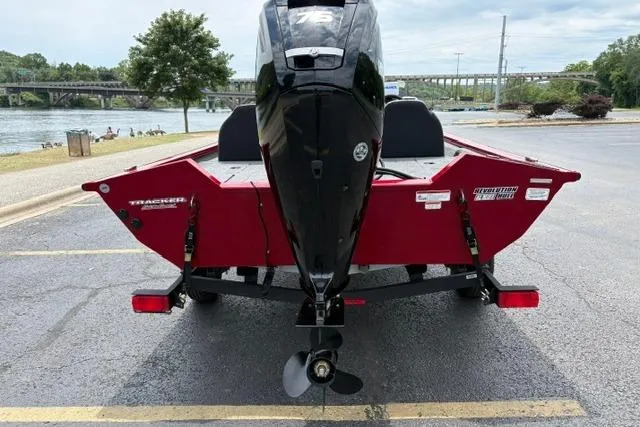 Slide: The Image of 2025 Tracker Off Road Pro Team 175 boat, red exterior, parked near a river. - 9