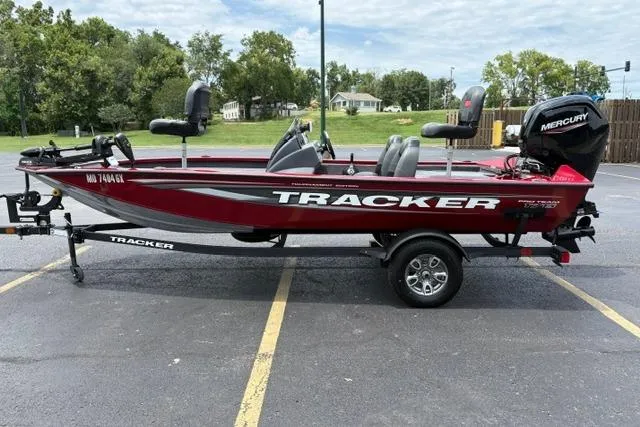 Slide: The Image of 2025 Tracker Off Road Pro Team 175 boat, red color, parked on asphalt with trailer. - 7