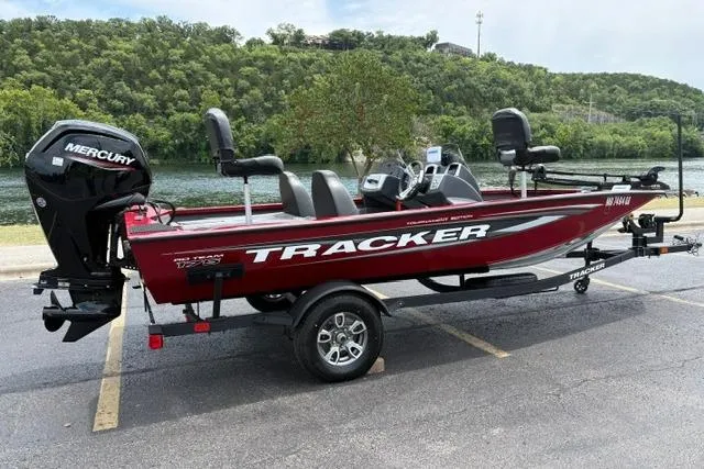 Slide: The Image of 2025 Tracker Off Road Pro Team 175 boat with Mercury engine, parked near a scenic lake. - 4