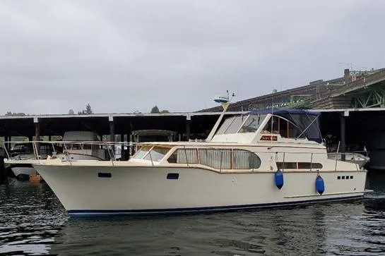 The Image of 1971 Monk 44 Express Bridge yacht docked near a marina under cloudy skies. - 0