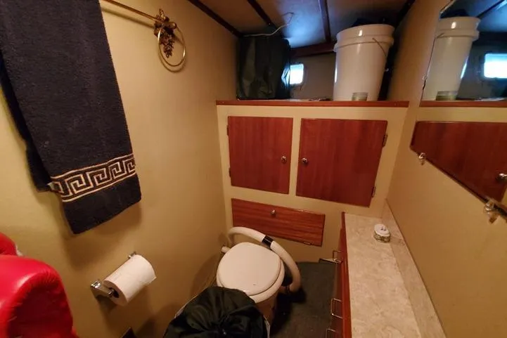 Slide: The Image of Bathroom interior of 1971 Monk 44 Express Bridge boat with wooden cabinets and towel rack. - 8
