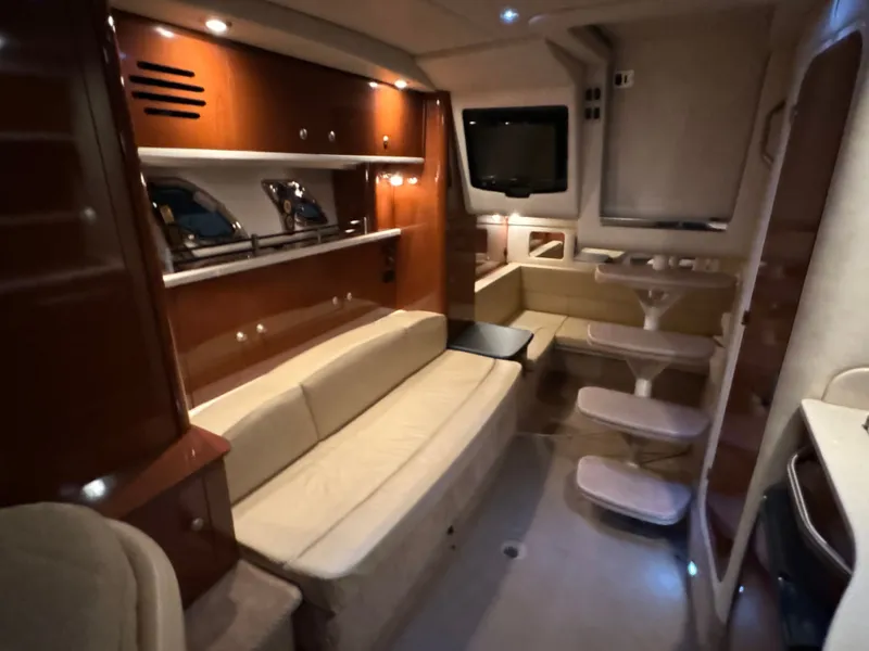 Slide: The Image of Interior of a 2008 Sea Ray Sundancer 310 with beige sofa, wooden cabinetry, and a small table. - 32
