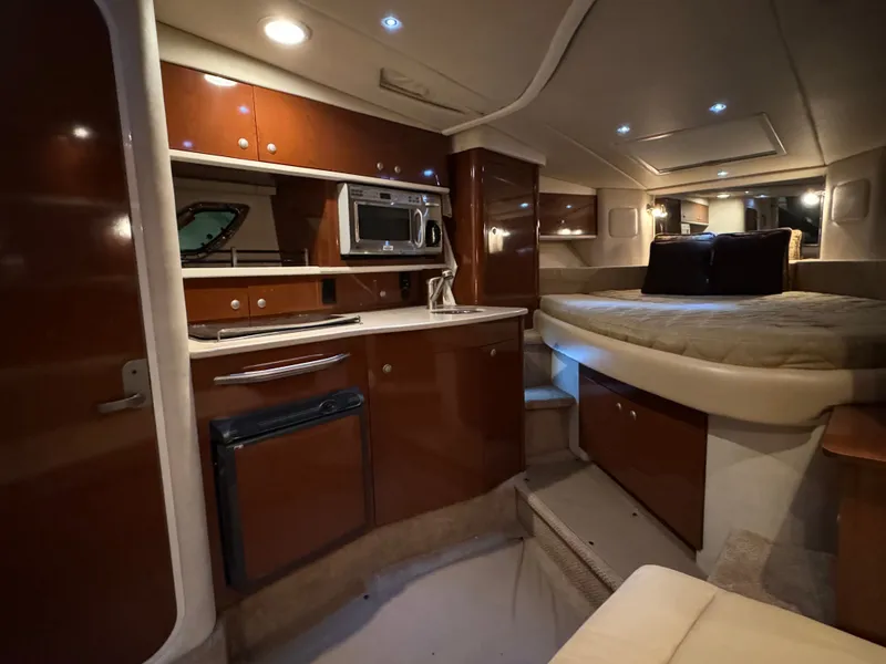 Slide: The Image of The interior cabin of a 2008 Sea Ray Sundancer 310 with a kitchenette and sleeping area. - 31