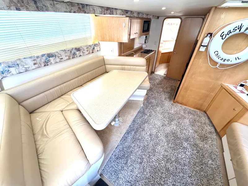 Slide: The Image of Interior of a 1998 Carver 35 with beige sofa and dining table. - 10