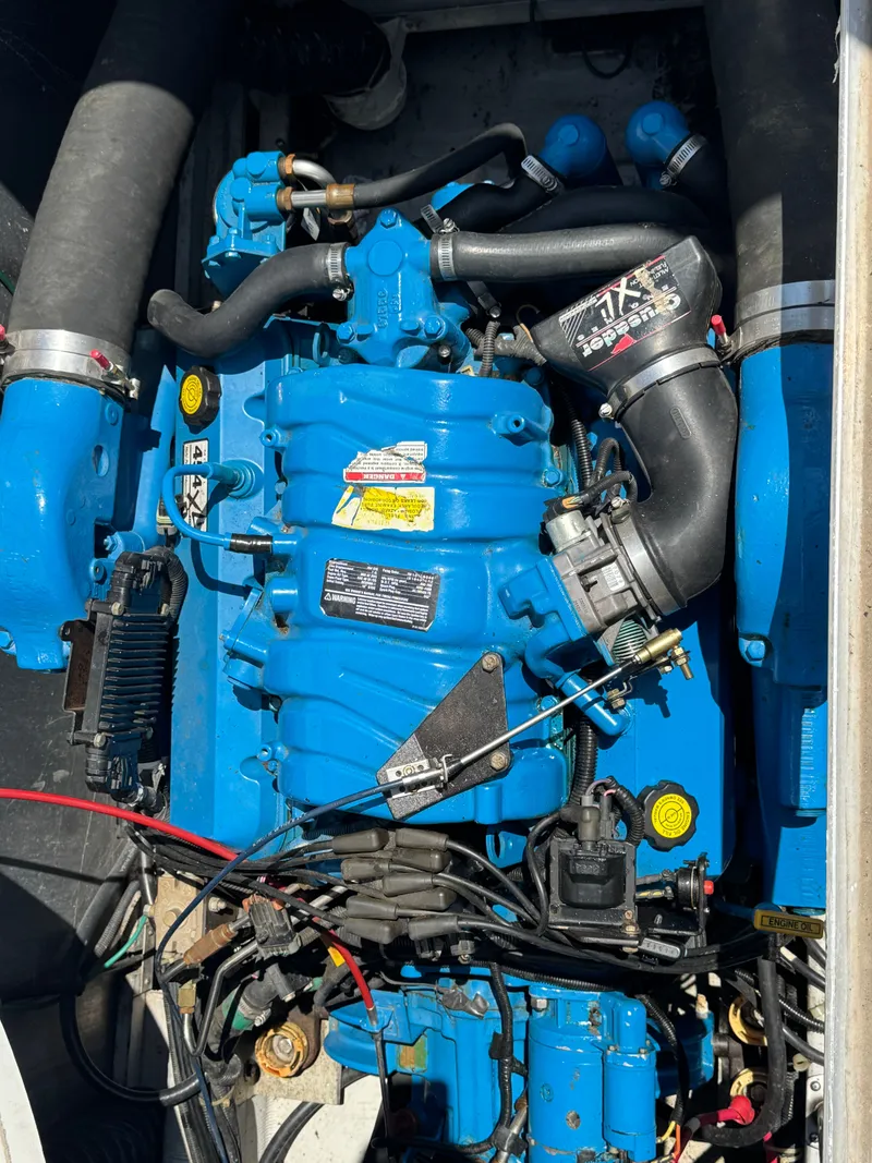 Slide: The Image of A blue boat engine with various hoses and cables. - 28