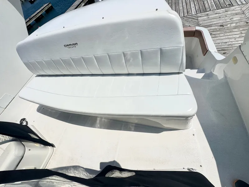 Slide: The Image of The 1998 Carver 35 features a white, cushioned bench seat on the deck. - 6