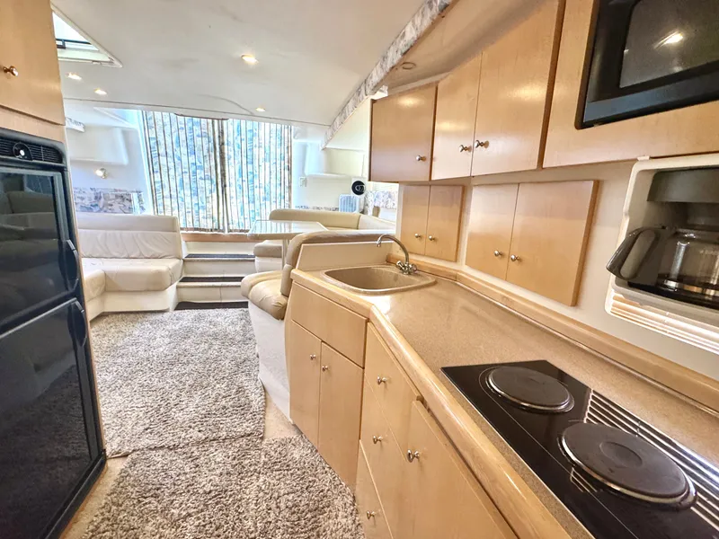 Slide: The Image of Interior of a 1998 Carver 35 with kitchen, sofa, and carpeted floor. - 13