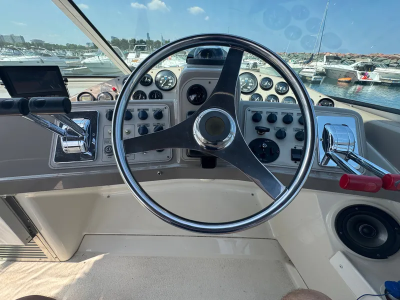 Slide: The Image of The image shows the helm of a 1998 Carver 35 boat in a marina. - 8
