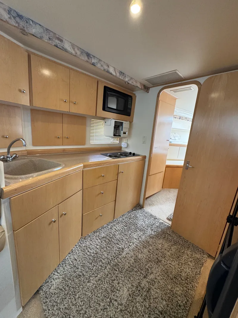 Slide: The Image of Interior of the 1998 Carver 35 featuring a kitchen and carpet. - 14
