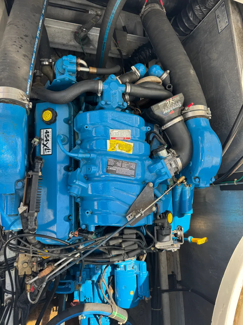 Slide: The Image of A blue boat engine with hoses and wires in an engine compartment. - 27