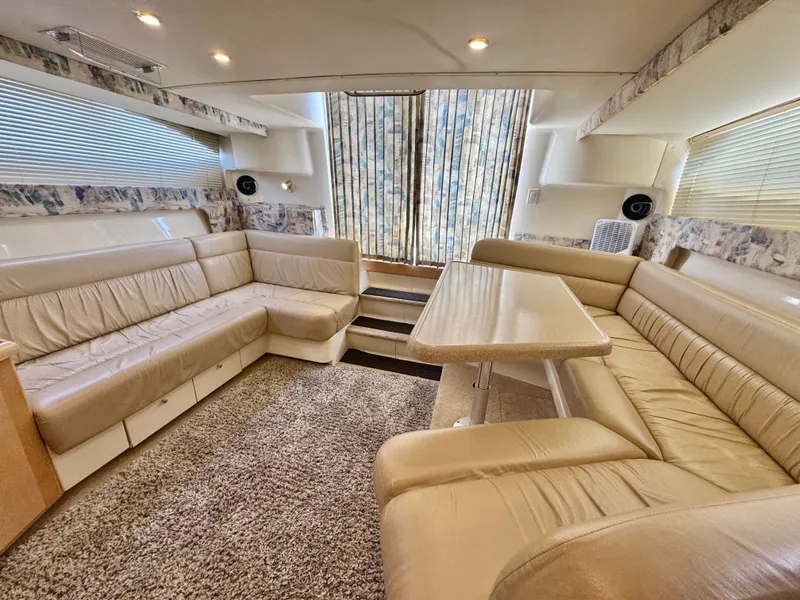 Slide: The Image of Interior of a 1998 Carver 35 with beige leather sofas and carpeted floor. - 11