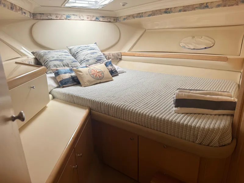 Slide: The Image of The cabin of a 1998 Carver 35 with a cozy bed and pillows. - 20